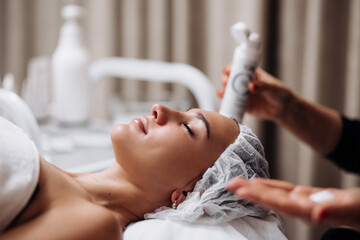 Side view portrait of young relaxed woman on procedure for improvements skin. Concept of special masks and creams for moisturizing. Self care spa concept. Advertising of cosmetology, cleanliness.