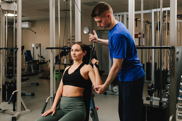 Removing physical disability with therapeutic gymnastics. Restoring hand mobility. Young girl is...