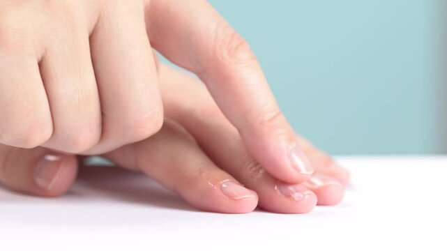 Moisturizing serum or oil for cuticles. The woman cares for hands and nails, close up. Woman applying oil from droper to nails, macro. Healthy nails concept. Hands massage with oil