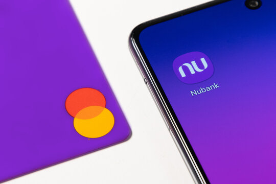 Nubank app showned on smartphone. Purple credit card with mastercard logo. White background