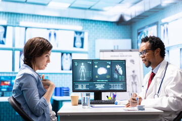 Medic expert showing the x ray imaging test results to patient at check up, discussing about treatment and medical advice. Doctor pointing at radiography scans for interpretation, diagnostic report.