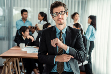 Portrait of happy businessman looking at camera with motion blur background of business people movement in dynamic business meeting. Habiliment