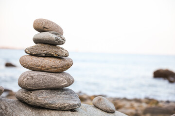 serene beach scene with smooth rocks stacked in a balanced formation. The tranquil atmosphere evokes a sense of zen, harmony, and peace, symbolizing balance and mindfulness in nature