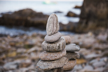 serene beach scene with smooth rocks stacked in a balanced formation. The tranquil atmosphere evokes a sense of zen, harmony, and peace, symbolizing balance and mindfulness in nature