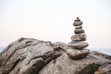 serene beach scene with smooth rocks stacked in a balanced formation. The tranquil atmosphere evokes a sense of zen, harmony, and peace, symbolizing balance and mindfulness in nature