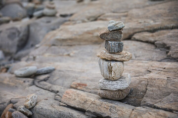 serene beach scene with smooth rocks stacked in a balanced formation. The tranquil atmosphere evokes a sense of zen, harmony, and peace, symbolizing balance and mindfulness in nature
