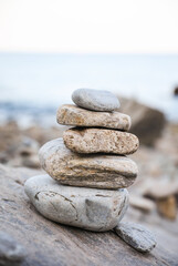 serene beach scene with smooth rocks stacked in a balanced formation. The tranquil atmosphere evokes a sense of zen, harmony, and peace, symbolizing balance and mindfulness in nature