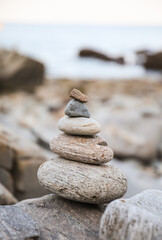 serene beach scene with smooth rocks stacked in a balanced formation. The tranquil atmosphere evokes a sense of zen, harmony, and peace, symbolizing balance and mindfulness in nature