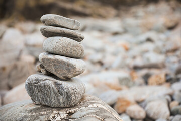serene beach scene with smooth rocks stacked in a balanced formation. The tranquil atmosphere...