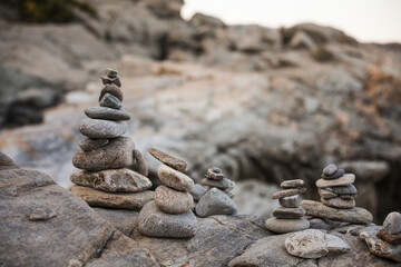 serene beach scene with smooth rocks stacked in a balanced formation. The tranquil atmosphere evokes a sense of zen, harmony, and peace, symbolizing balance and mindfulness in nature