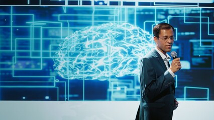 Tech company CEO using summit as platform to launch latest AI products. Manager uses mic to talk at forum to connect with business leaders and investors interested in artificial intelligence, camera B