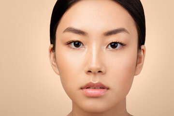 Fototapeta premium Pure Beauty. Closeup Of Asian Young Woman's Face With Natural Makeup And Calm Genuine Emotions Over Light Gray Studio Background. Portrait Of Attractive Korean Woman. Cropped