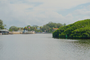 Wide view over water to Coffee Pot Bayou bird preserve a small island packed with nesting pelicans,...