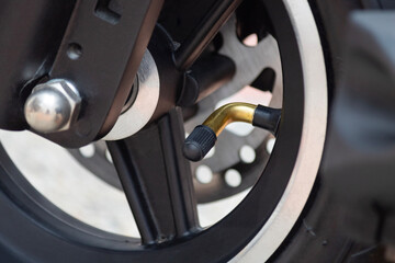 Obraz premium Macro photo to a valve wheel of a electric scooter with rim and tire