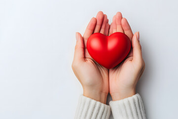 Obraz premium Hands Holding a Red Heart on White Background