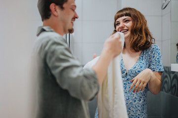 A cheerful couple getting ready in the bathroom, sharing a joyful moment before heading out for an evening adventure.