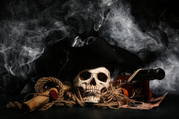 Human skull with toy model of cannon, pirate hat, world map and scroll on black background