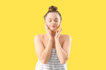 Young woman after washing hair on yellow background