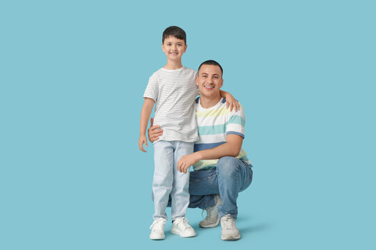 Cute little boy with his father on blue background