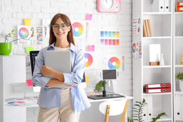 Female graphic designer with laptop in office