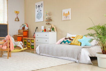 Interior of children's room with bed, drawers and pictures