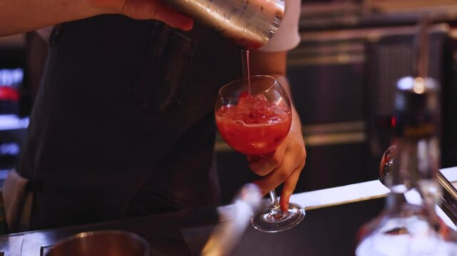 Bartender working, beautiful row line of different coloured liquor alcohol cocktails on a party in a bar catering banquet on event, barman mixing drinks and beverages in club in slow motion
