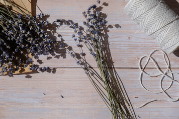 Woman creating bouquets of dry lavender flowers. Process of making scented bouquets and sachet from...