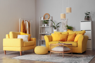Interior of living room with yellow sofa, armchair and green plants