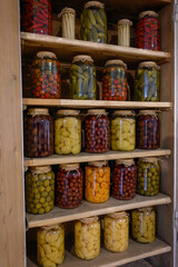 Demonstration of a large supply of preserves in a cupboard in the wall.
