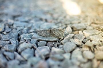 Close up of gravel stones form a beautiful and rugged pattern in the morning sun. Day, outdoor. 
