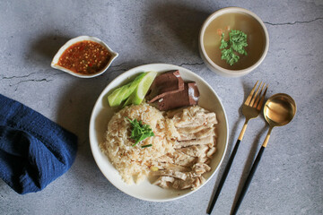 Rice steamed with chicken soup and dipping sauce or Khao Mun Kai in white plate. thai food concept.