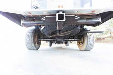Underneath picture of an American 4x4 truck, backside hitch receiver, axles shock absorbers yoke...