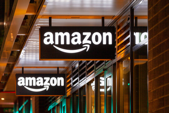 Portland, Oregon, USA-May 15, 2019: Amazon Hub Locker store with its big illuminated logo signage banner at the facade of the shop. Captured at night. High quality picture for download.
