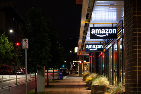 Portland, Oregon, USA-May 15, 2019: Amazon Hub Locker store with its big illuminated logo signage banner at the facade of the shop. Captured at night. High quality picture for download.