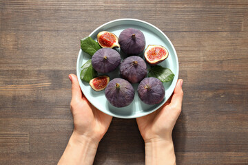 Fresh ripe figs in a bowl on a wooden background © Atlas