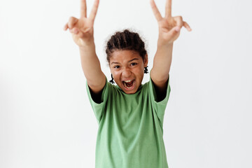 stylish young boy in green shirt flashing peace signs with both hands, exuding trendy vibes