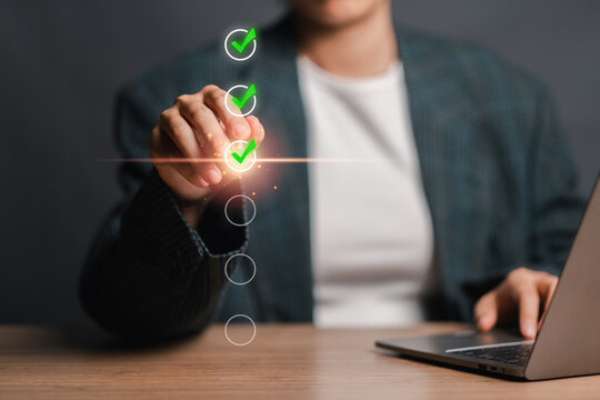 A business professional using a laptop to conduct an online survey, interacting with a digital checklist interface. Concept of modern data collection and feedback.