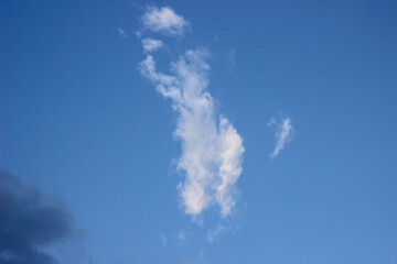Sun shining through the puffy clouds. Sky view. Beautiful sunny sky. Background with clouds on blue...
