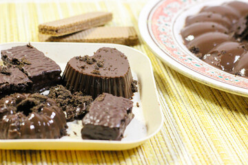Chocolate pudding on white plate with woven tablecloth isolated