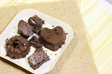 Chocolate pudding on white plate with woven tablecloth isolated