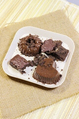 Chocolate pudding on white plate with woven tablecloth isolated