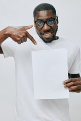 smiling man with blank sheet of paper, casual attire, pointing gesture, white background, cheerful...