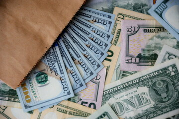 Big amount of US dollar bills in different nominations on table. Many dollar banknotes under natural light