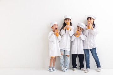 Fototapeta premium 給食着を着てコッペパンを食べる小学生