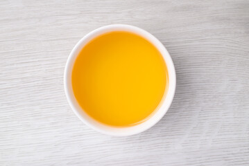 Sesame oil (Cold pressed) in bowl on white table, Food ingredient, Top view