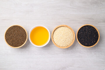 Perilla seeds, White and black sesame seeds and oil (Cold pressed) in bowl on white table, Food ingredient, Top view