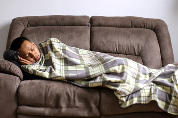 Portrait Of Young Asian Man Wrapped In Blanket Sleeping At Home