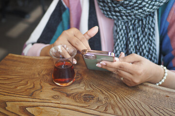  women hand holding smart phone sitting on cafe 