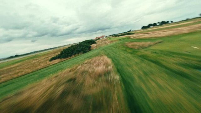 FPV drone flyover Ireland links golf course par five, speed through tall grass, bunkers and green fairways