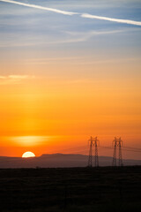 orange sunset with large power lines 